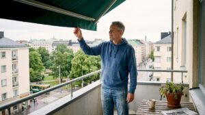 Asukas tarkistaa parvekkeen markiisia Helsingissä